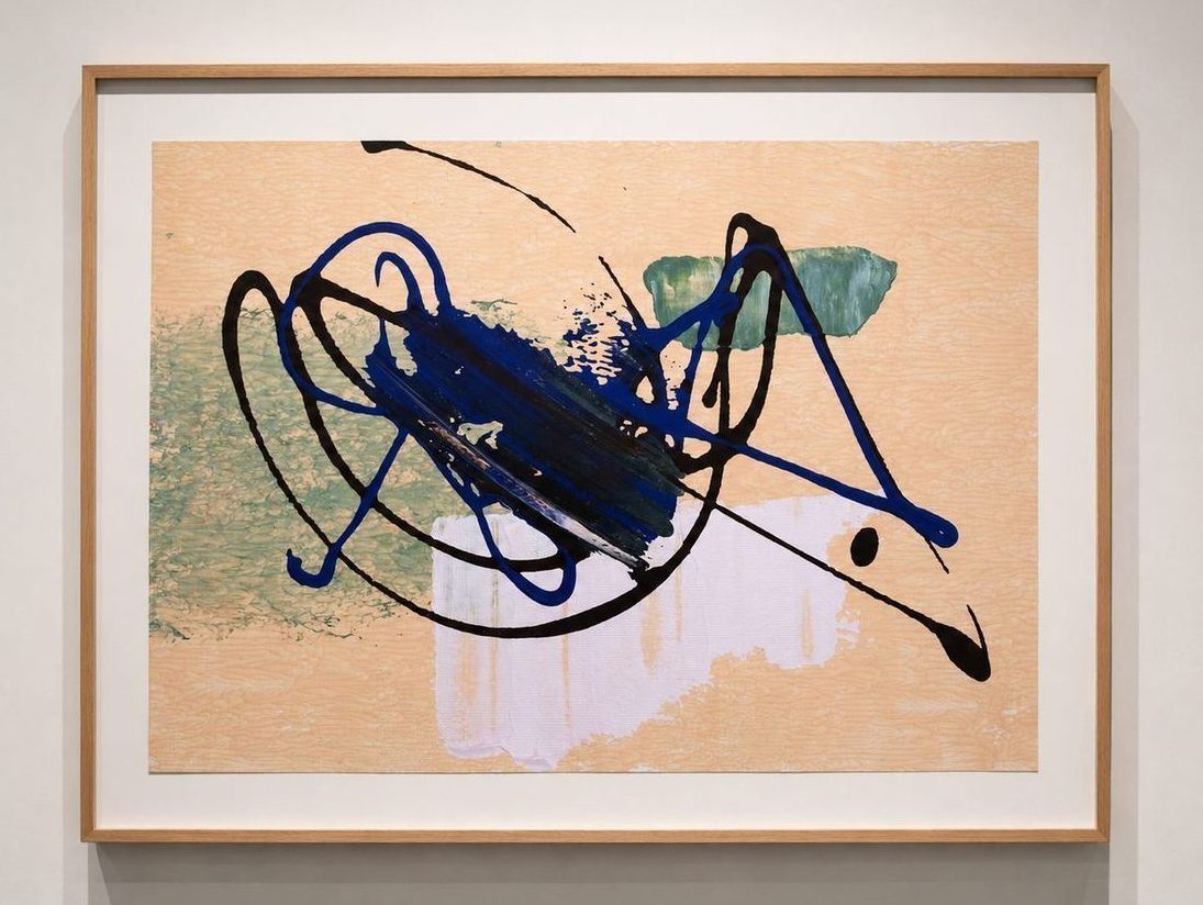 A peach work with dark blue and black loops, in an oak frame