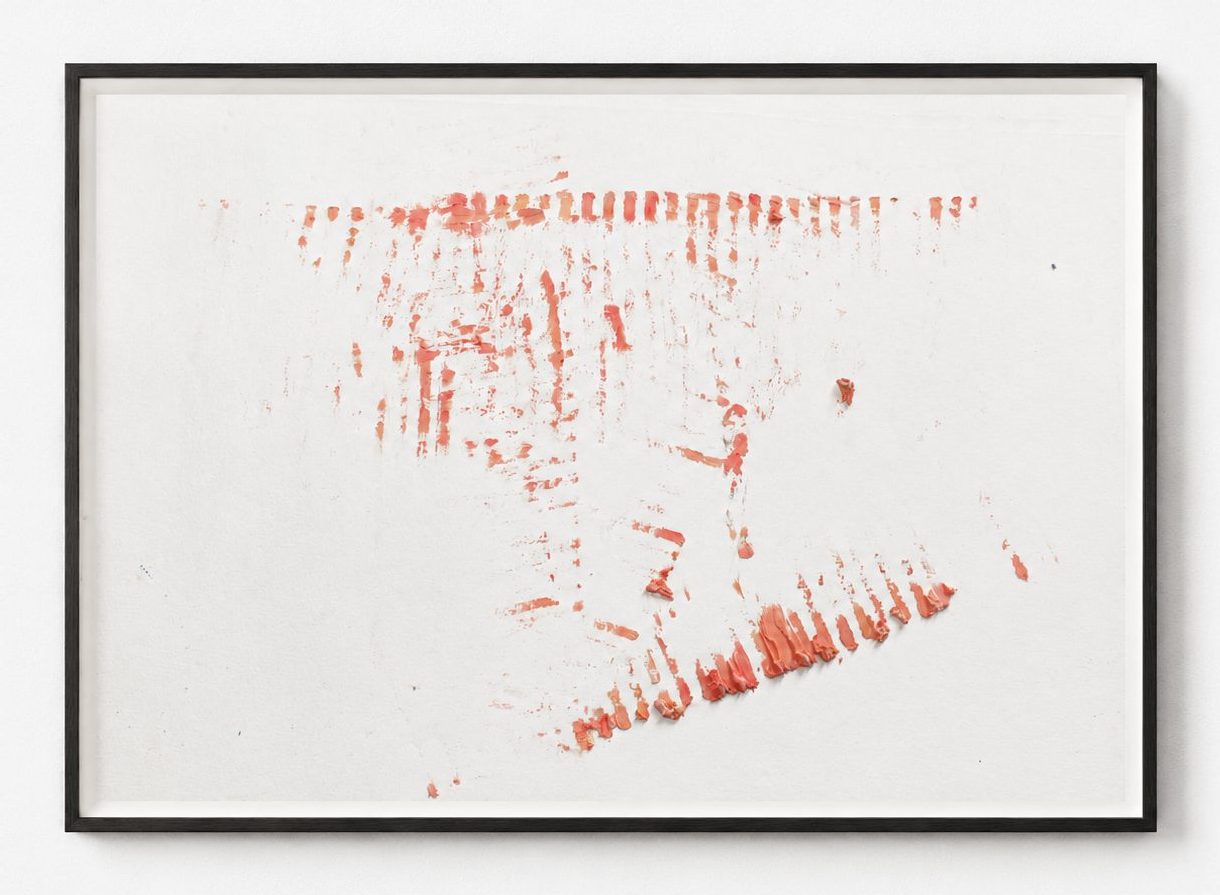 A faint orange smear on white paper, in a black frame