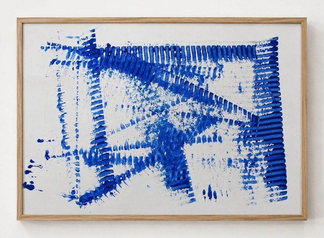 Blue combed strokes across white paper, in an oak frame