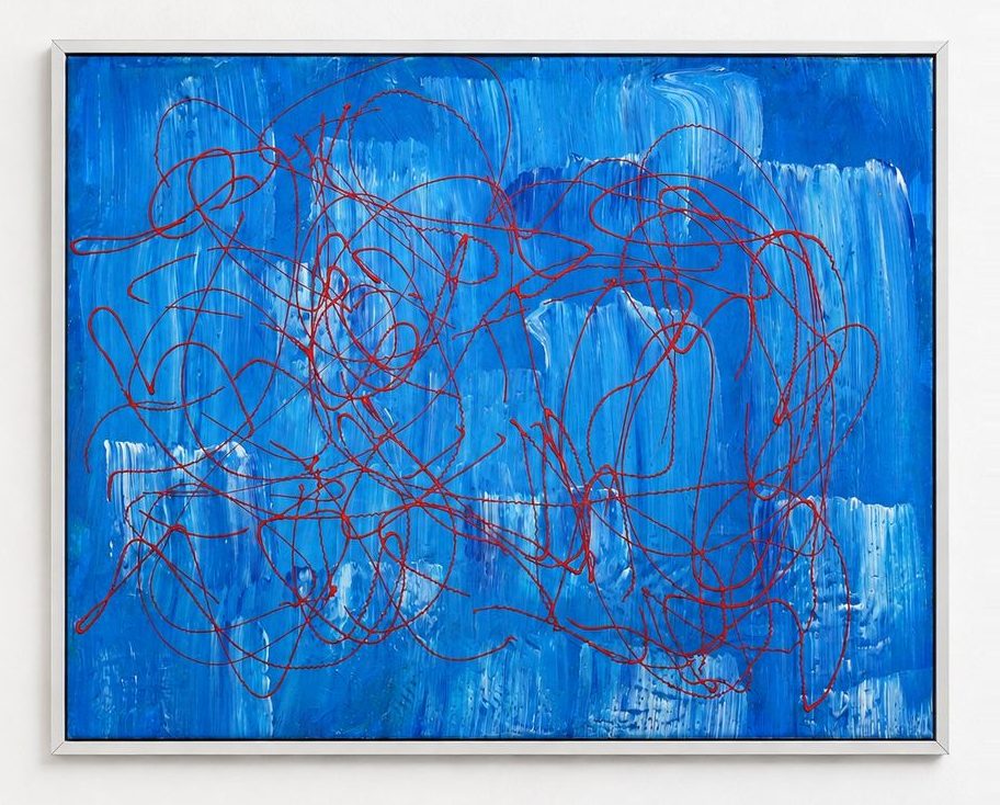 A blue canvas with red looping lines, in a silver frame